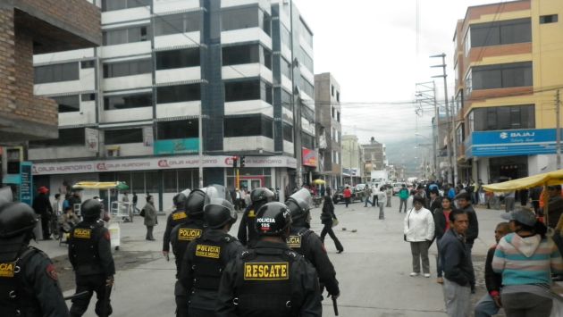 BATALLA CAMPAL. La Policía tuvo que lanzar gases lacrimógenos para controlar a la enardecida turba. (Andina)