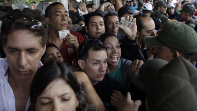 Militares venezolanos tratan de clamar a ola de compradores afuera de la tienda Daka en Caracas. (AP)