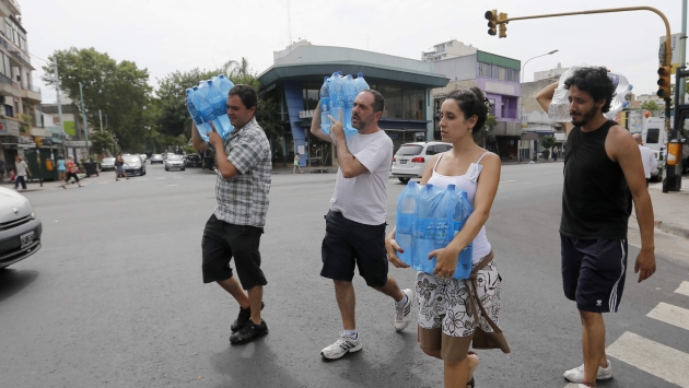 CRECE LA EMERGENCIA. En las zonas más afectadas de la capital argentina reparten agua potable. (Reuters)