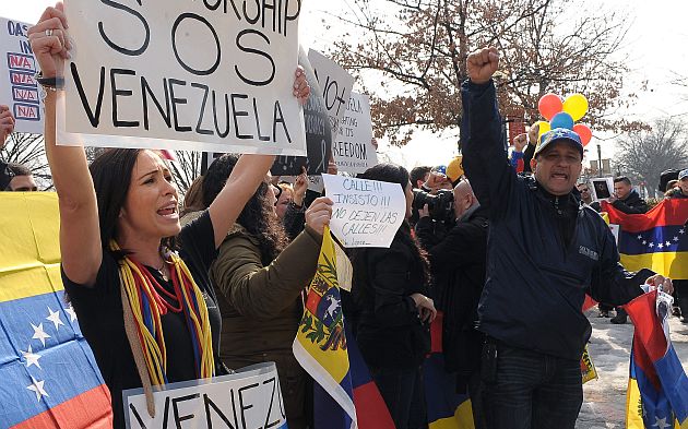 Decenas de personas protestan frente a la sede de la OEA, en Washington, por su silencio ante la situación en Venezuela. (EFE)