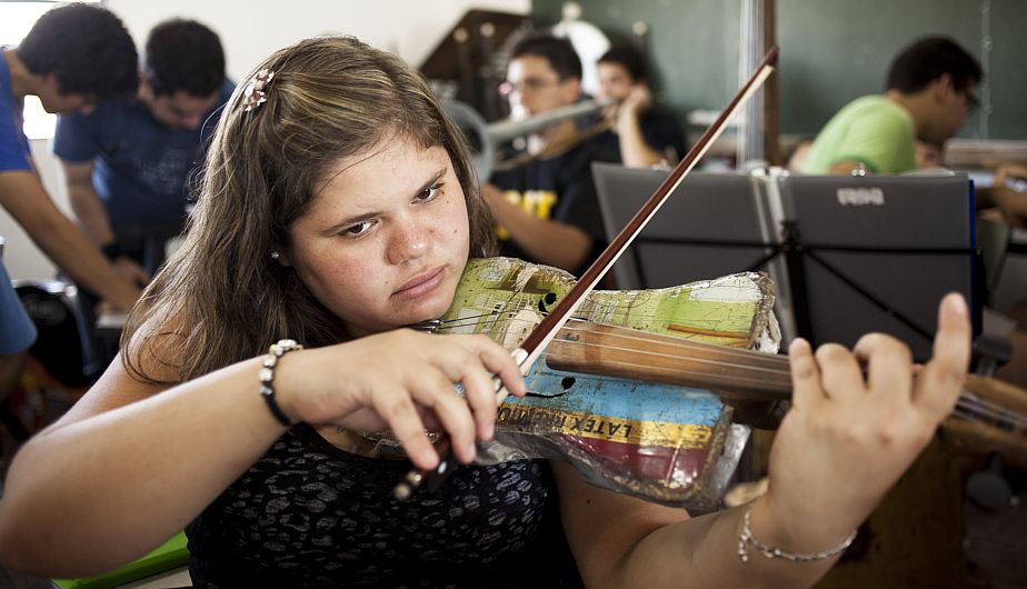 Niña tocando un violín hecho con material reciclado, durante un ensayo de la Orquesta de Instrumentos Reciclados de Cateura, en Asunción (Paraguay). (EFE)