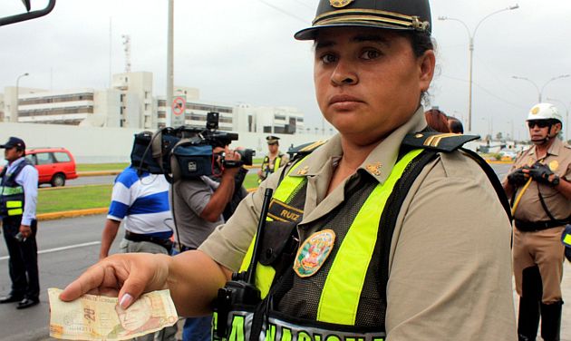La mujer policía que denunció el soborno muestra la prueba del delito. (Andina)