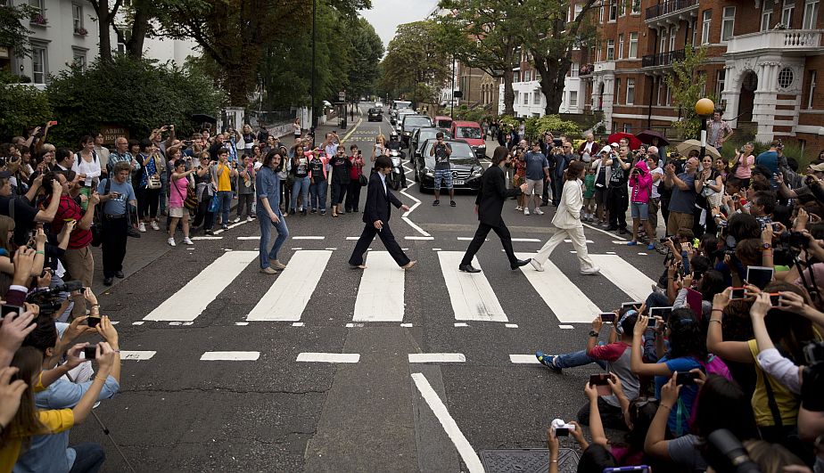 El elenco del musical ‘Let It Be’ se reunió en la popular calle para recrear el histórico momento. (AP)