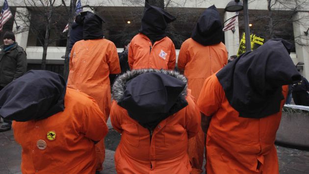 Manifestantes vestidos como detenidos torturados por Estados Unidos en el exterior del edificio de la CIA. (AP)
