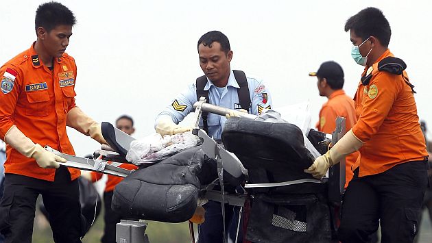 AirAsia: Rescatistas trasladan restos de un asiento del avión siniestrado. (EFE)