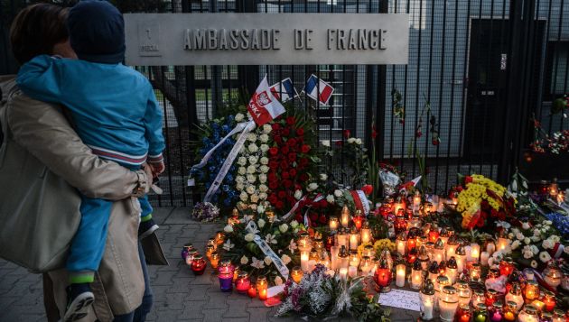Personas dejan flores en las afueras de la embajada de Francia en Polonia por las víctimas de este último jueves. (EFE)