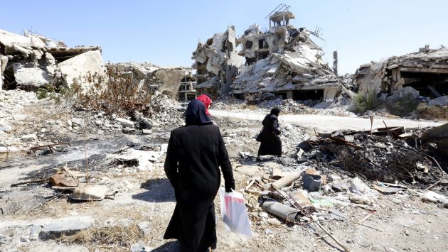 Mujeres sirias caminan entre las ruinas de la ciudad Homs, Siria. (EFE)