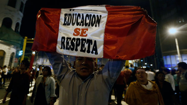 Un hombre levanta un cartel en la marcha a favor de Jaime Saavedra. (Renzo Salazar)
