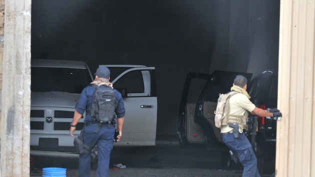 Policía mexicana ingresando a un garage donde encuentra autos con impacto de balas tras enfrentamiento. (Foto: EFE)
